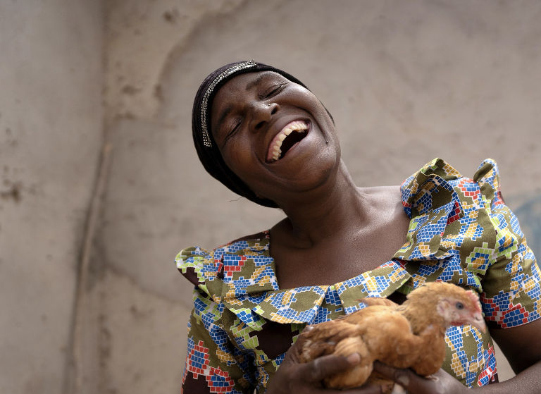 Happy woman holding a chicken